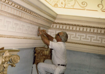 Artist applying slow drying adhesive to Assembly Chamber ornamentation