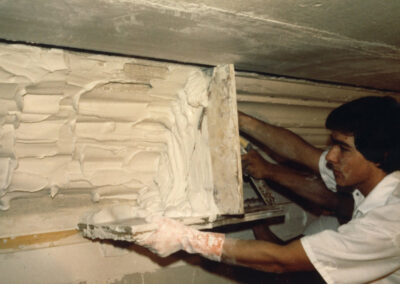 Artist using template for decorative plasterwork molding