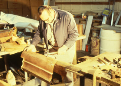 Restoration worker shaping duplicates of the original metal dome shingles